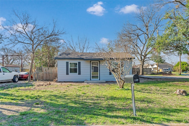 view of front of property featuring a front lawn and fence