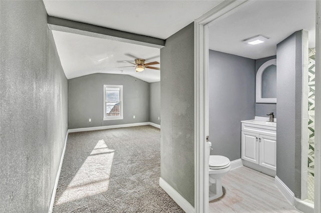 bathroom featuring toilet, lofted ceiling, a ceiling fan, baseboards, and vanity