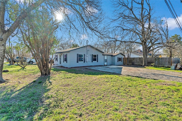 view of front of home featuring a patio area, fence, and a front lawn