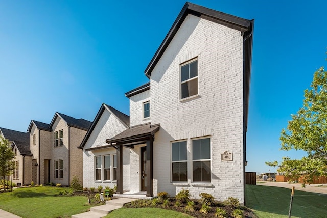 view of front of home featuring a front yard and brick siding