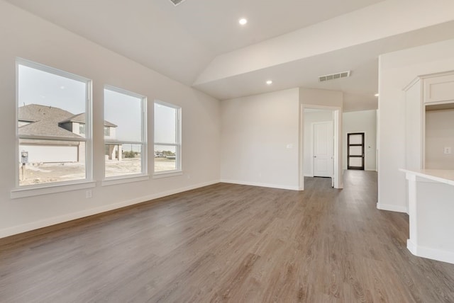 unfurnished room with visible vents, baseboards, vaulted ceiling, recessed lighting, and light wood-style floors