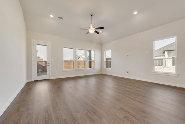 unfurnished living room featuring visible vents, lofted ceiling, dark wood finished floors, baseboards, and ceiling fan