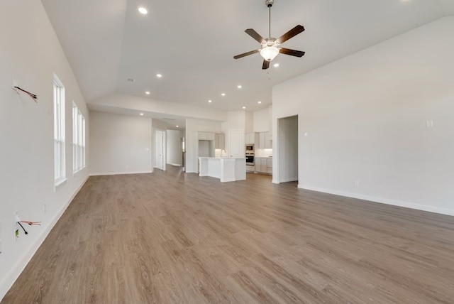 unfurnished living room with light wood-style flooring, recessed lighting, a ceiling fan, and baseboards