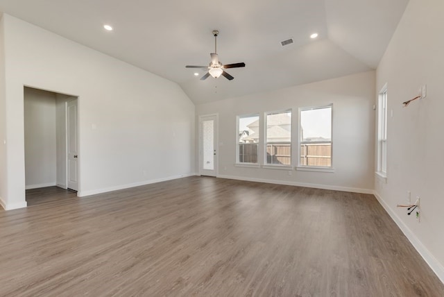 unfurnished living room with lofted ceiling, wood finished floors, a ceiling fan, and visible vents