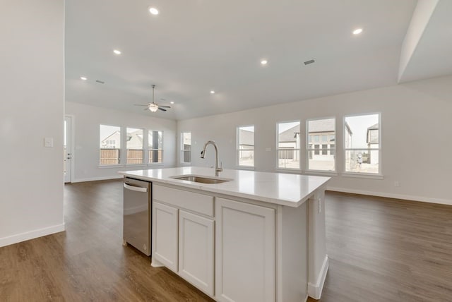 kitchen featuring a sink, open floor plan, light countertops, dishwasher, and dark wood-style flooring