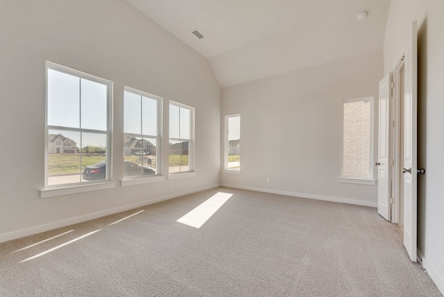 spare room featuring light carpet, visible vents, high vaulted ceiling, and baseboards