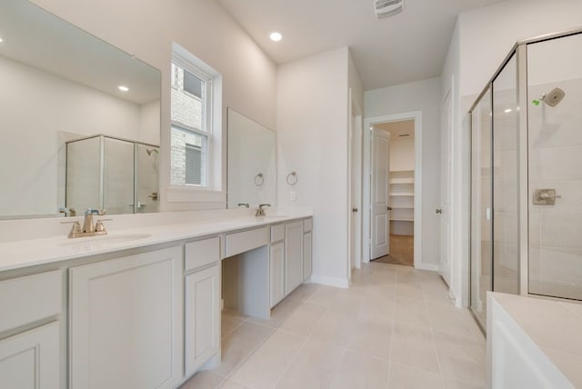 full bath featuring double vanity, visible vents, a shower stall, and a sink