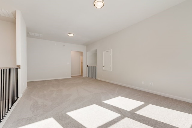 unfurnished room with visible vents, baseboards, and light colored carpet