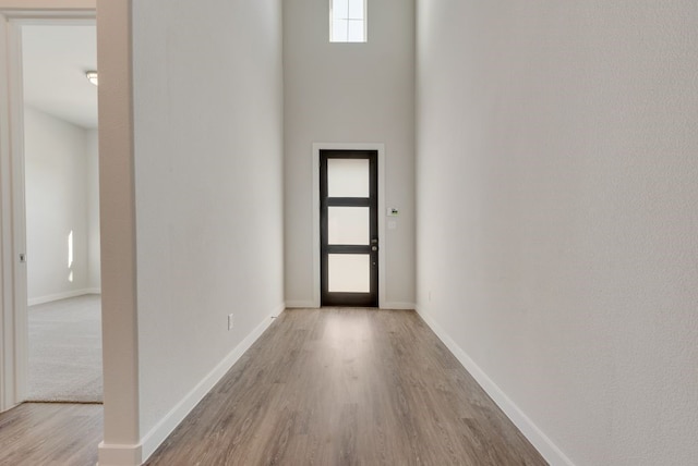 foyer entrance with wood finished floors and baseboards