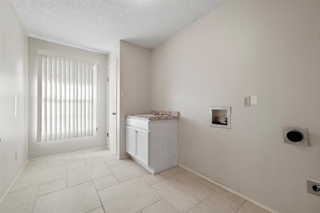 laundry room with electric dryer hookup, a textured ceiling, cabinet space, light tile patterned floors, and hookup for a washing machine