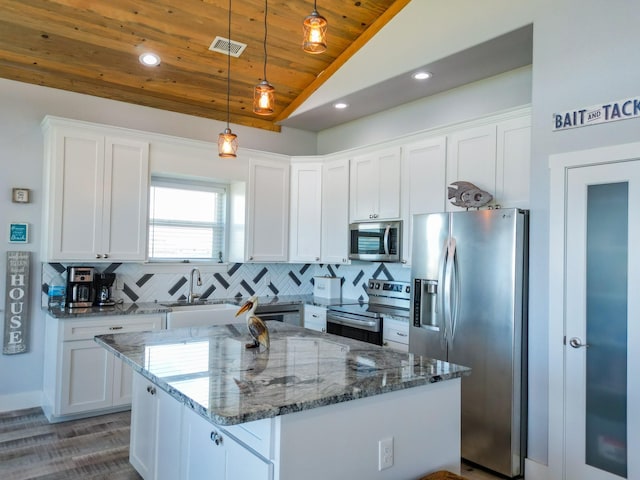 kitchen featuring visible vents, backsplash, white cabinetry, appliances with stainless steel finishes, and lofted ceiling