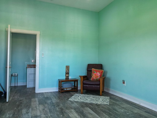 sitting room with dark wood finished floors and baseboards