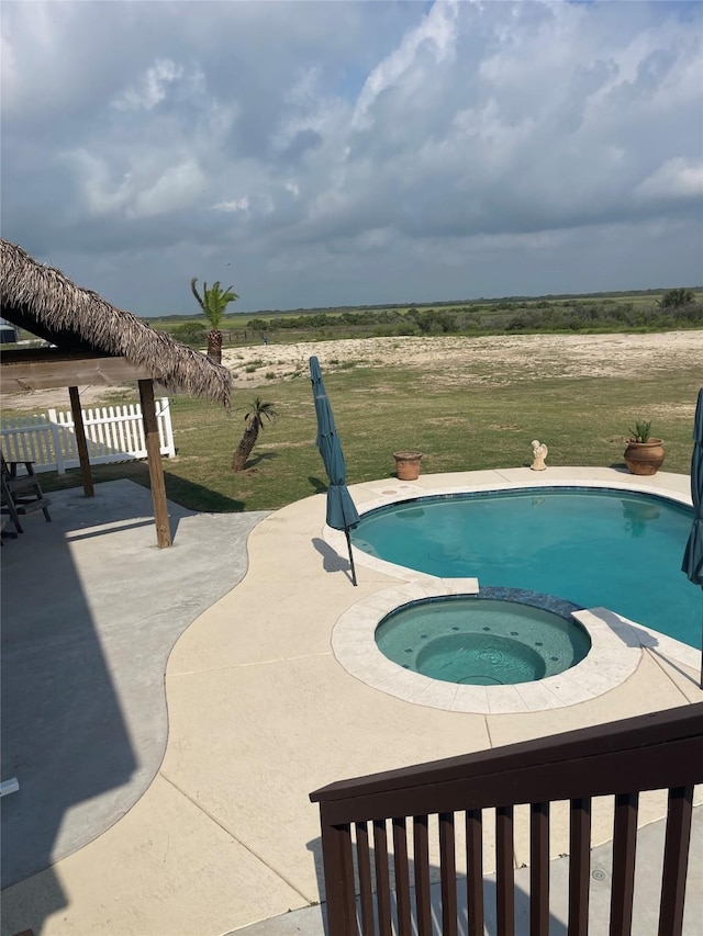 view of swimming pool with a yard, a patio area, and a pool with connected hot tub