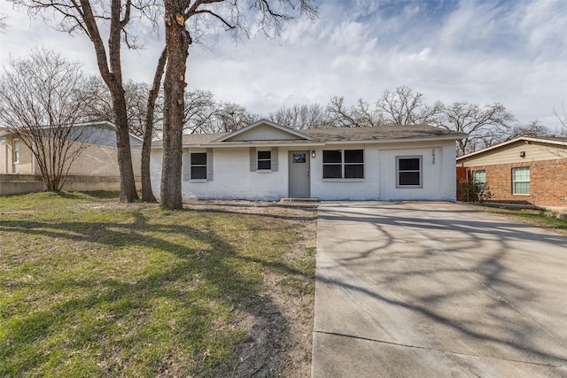 view of front of home with concrete driveway, a front lawn, and a shingled roof