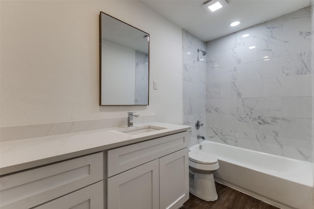 bathroom featuring shower / bathing tub combination, toilet, wood finished floors, and vanity