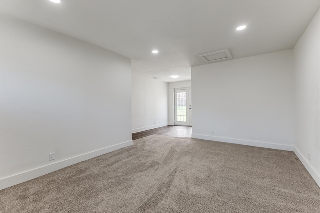 spare room with carpet flooring, recessed lighting, attic access, and baseboards