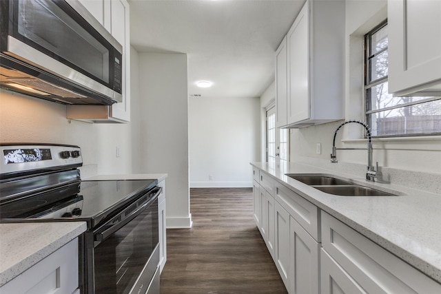 kitchen featuring white cabinetry, dark wood-style floors, appliances with stainless steel finishes, and a sink