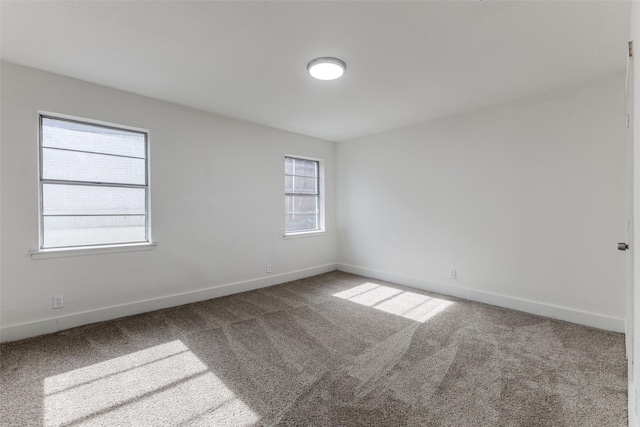 spare room with baseboards and carpet