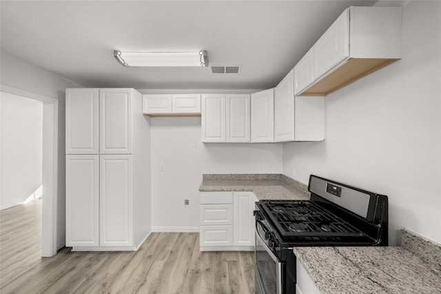 kitchen with light stone countertops, visible vents, stainless steel range with gas cooktop, light wood-style flooring, and white cabinets