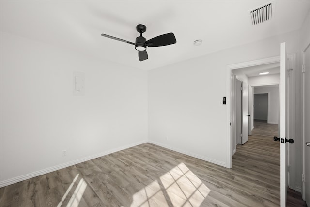 spare room with visible vents, baseboards, ceiling fan, and wood finished floors