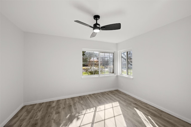 empty room featuring a ceiling fan, baseboards, and wood finished floors