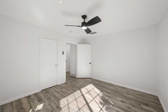 unfurnished bedroom with visible vents, a ceiling fan, baseboards, and wood finished floors