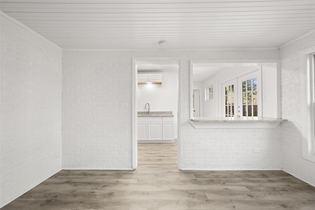 interior space with wood finished floors and brick wall