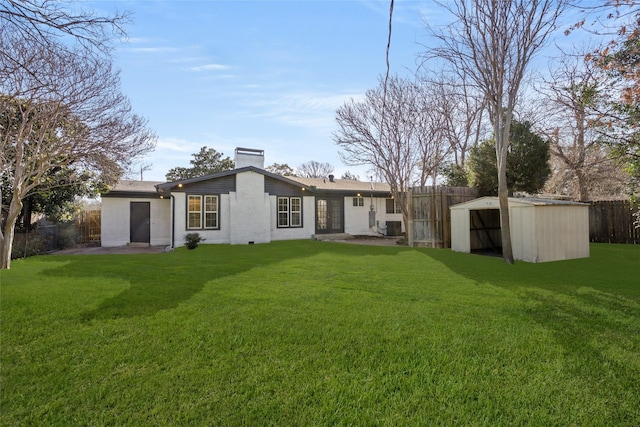 back of property featuring a patio area, a lawn, an outbuilding, and a fenced backyard