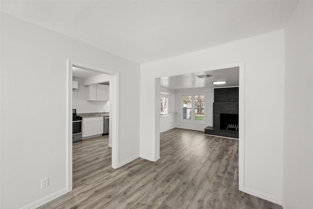 unfurnished living room with visible vents, baseboards, light wood-style flooring, and a fireplace