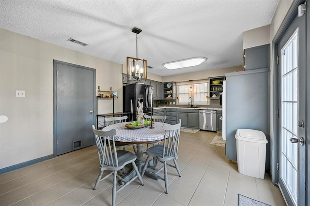 dining room with light tile patterned flooring, visible vents, and a wealth of natural light