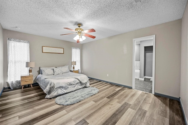 bedroom with a textured ceiling, a ceiling fan, baseboards, and wood finished floors