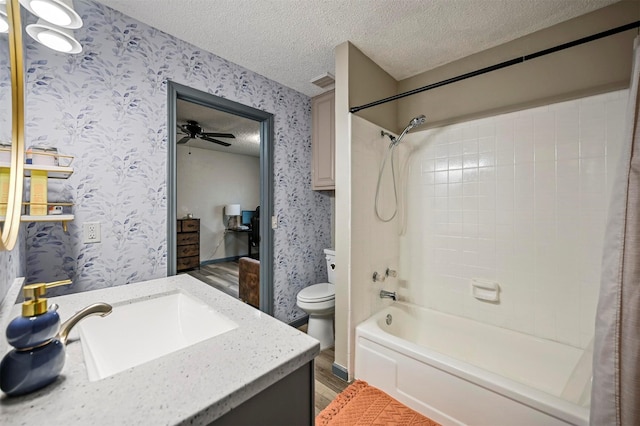 full bathroom featuring visible vents, wallpapered walls, toilet, vanity, and a textured ceiling