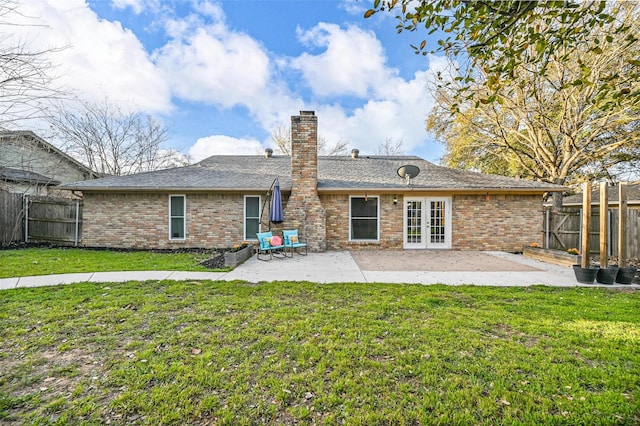 back of property featuring a fenced backyard, a lawn, french doors, and a patio