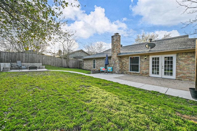 view of yard featuring a fenced backyard, french doors, and a patio