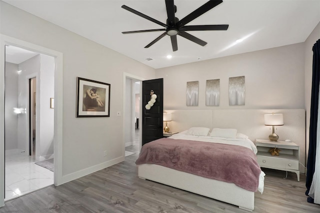 bedroom featuring visible vents, wood finished floors, connected bathroom, baseboards, and ceiling fan