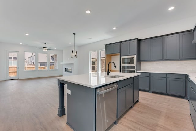 kitchen with a sink, light countertops, a wealth of natural light, and stainless steel appliances