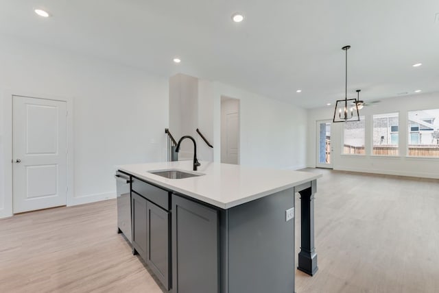 kitchen featuring gray cabinetry, light wood-style flooring, a sink, light countertops, and dishwasher