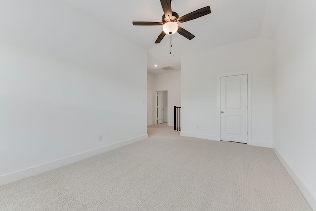 spare room with a ceiling fan, light colored carpet, and baseboards