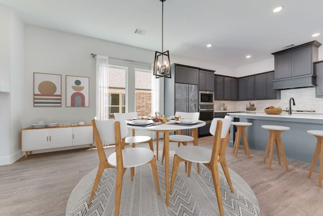 dining area with visible vents, recessed lighting, light wood-style floors, an inviting chandelier, and baseboards