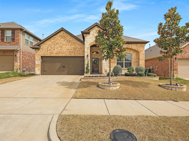 view of front of property with a garage, stone siding, brick siding, and concrete driveway