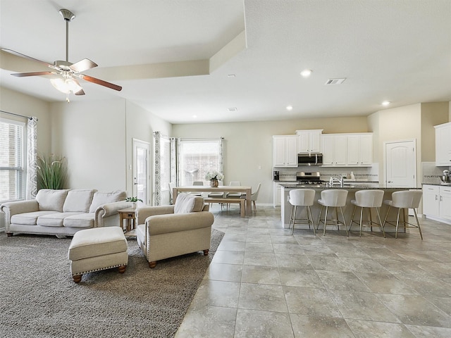 living room with recessed lighting, a healthy amount of sunlight, visible vents, and ceiling fan