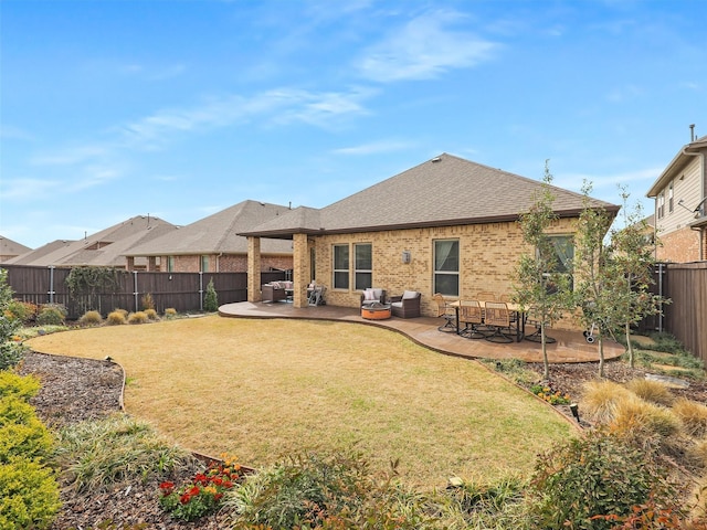 rear view of house with roof with shingles, a yard, a fenced backyard, a patio area, and brick siding