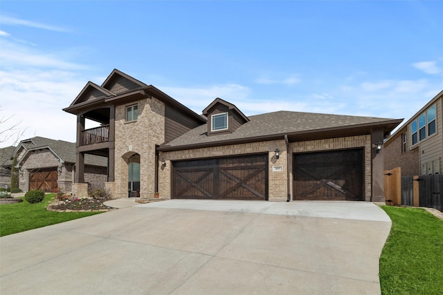 view of front facade with a balcony, roof with shingles, an attached garage, concrete driveway, and brick siding