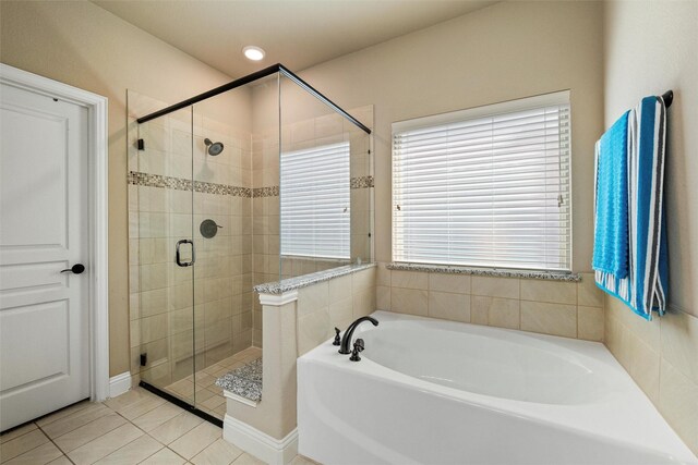 bathroom with a bath, a shower stall, and tile patterned floors