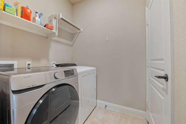 laundry area with laundry area, light tile patterned floors, separate washer and dryer, and baseboards