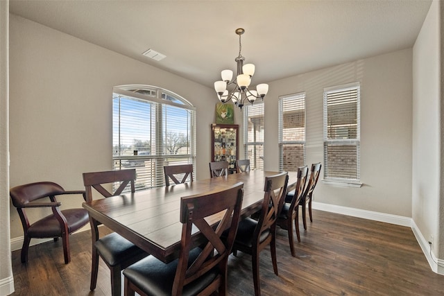 dining area with visible vents, baseboards, a notable chandelier, and dark wood finished floors