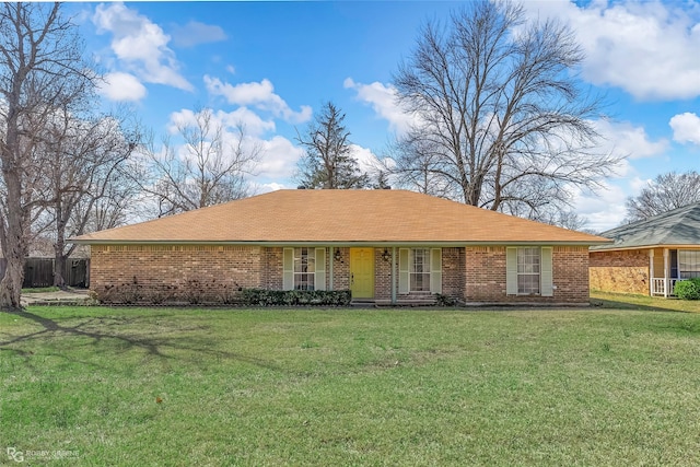 ranch-style home featuring brick siding and a front yard