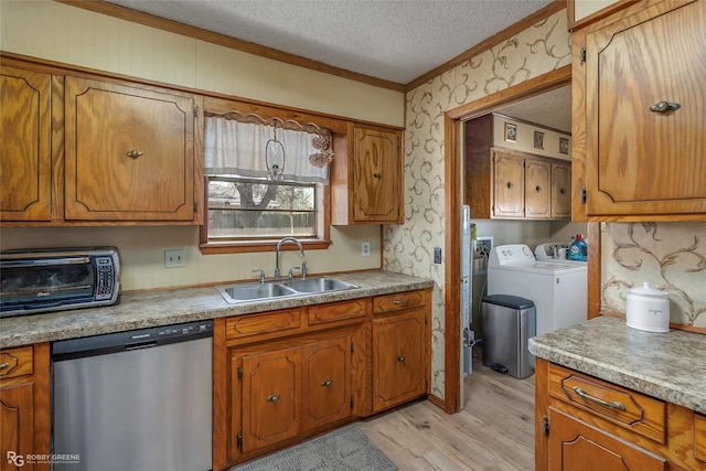 kitchen with a sink, wallpapered walls, dishwasher, a textured ceiling, and separate washer and dryer