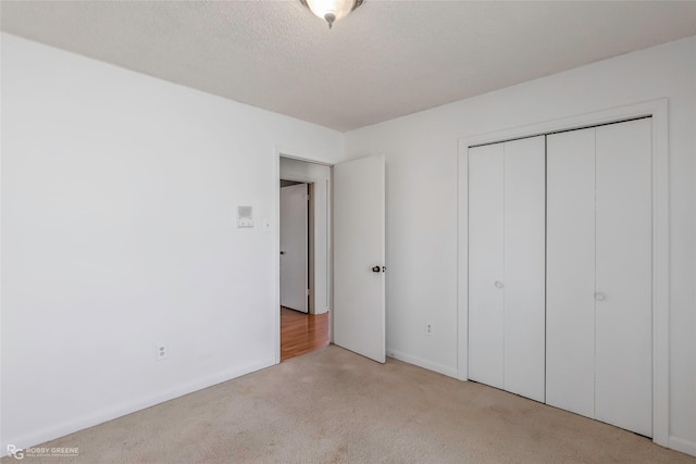 unfurnished bedroom with a closet, a textured ceiling, and carpet flooring