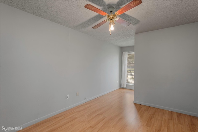 unfurnished room featuring a textured ceiling, baseboards, ceiling fan, and wood finished floors